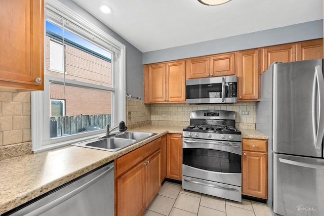 kitchen with light tile patterned floors, sink, appliances with stainless steel finishes, and tasteful backsplash