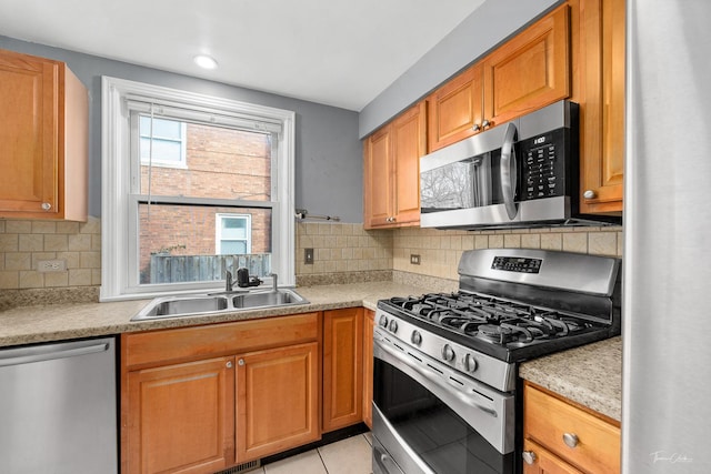 kitchen featuring decorative backsplash, light tile patterned flooring, sink, and appliances with stainless steel finishes