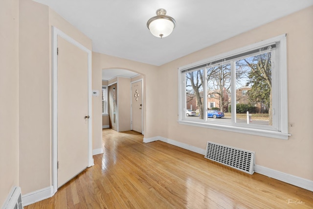 interior space with baseboard heating and light hardwood / wood-style floors