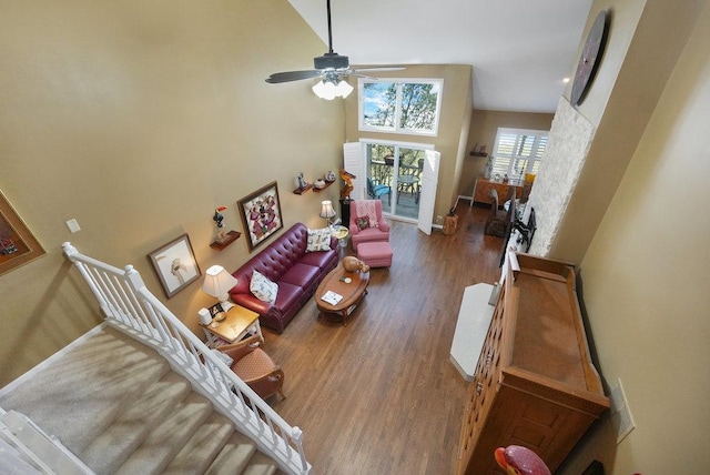 living room featuring a high ceiling, dark hardwood / wood-style floors, and ceiling fan