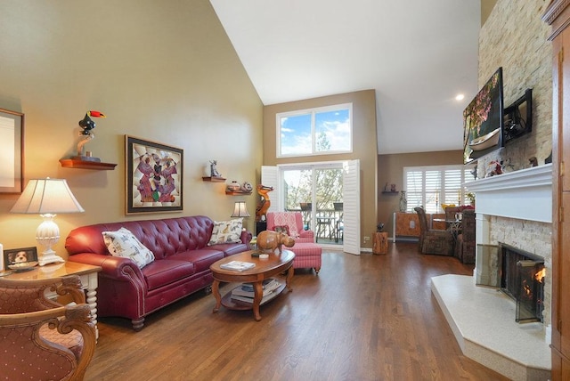 living room featuring a stone fireplace, dark wood-type flooring, and high vaulted ceiling