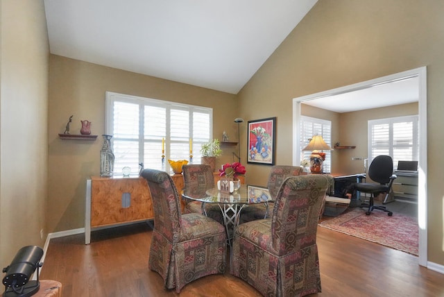 dining space featuring lofted ceiling and dark hardwood / wood-style floors