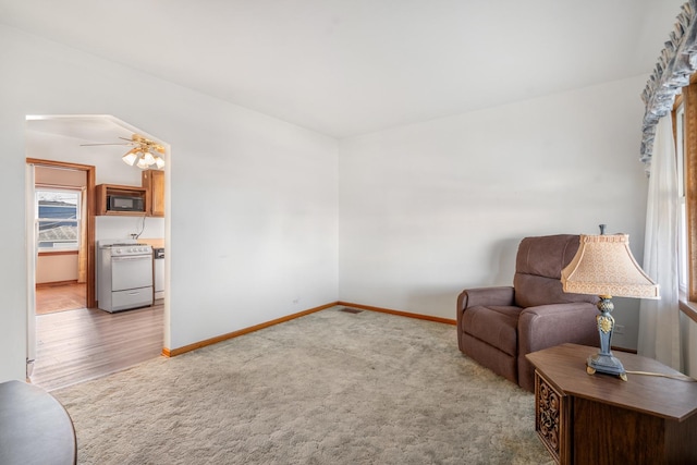 living area with light wood-type flooring and ceiling fan