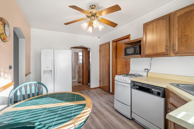 kitchen featuring ceiling fan, white appliances, and light hardwood / wood-style flooring