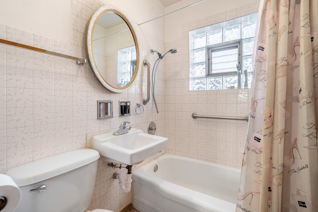 full bathroom with toilet, sink, tile walls, and shower / tub combo