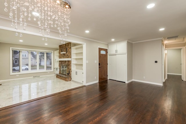 unfurnished living room featuring a fireplace, an inviting chandelier, dark wood-type flooring, and ornamental molding