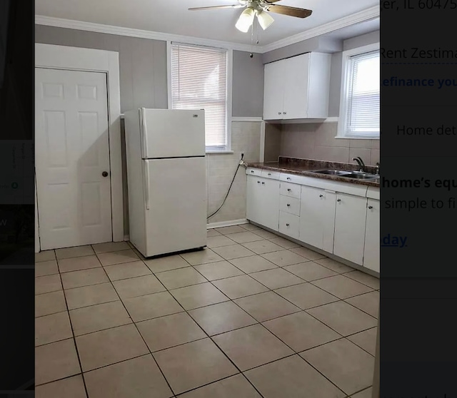 kitchen featuring ceiling fan, sink, white refrigerator, crown molding, and white cabinets