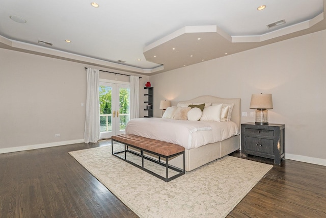 bedroom with dark hardwood / wood-style flooring, french doors, access to outside, and a tray ceiling