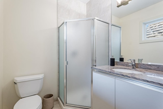 bathroom featuring vanity, an enclosed shower, and toilet