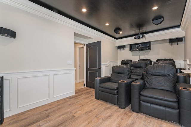 cinema with ornamental molding and light hardwood / wood-style flooring