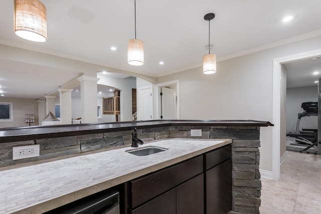 kitchen with pendant lighting, ornamental molding, and sink