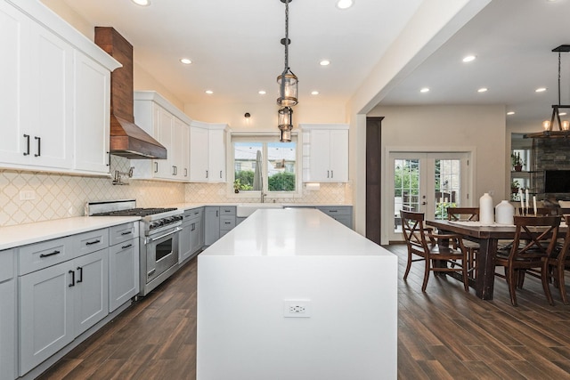 kitchen with decorative light fixtures, a center island, dark hardwood / wood-style flooring, and high end range