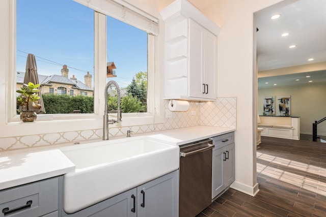 kitchen featuring gray cabinetry, dishwasher, dark hardwood / wood-style flooring, and sink