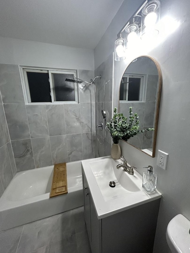 full bathroom featuring tile patterned flooring, vanity, tiled shower / bath combo, and toilet