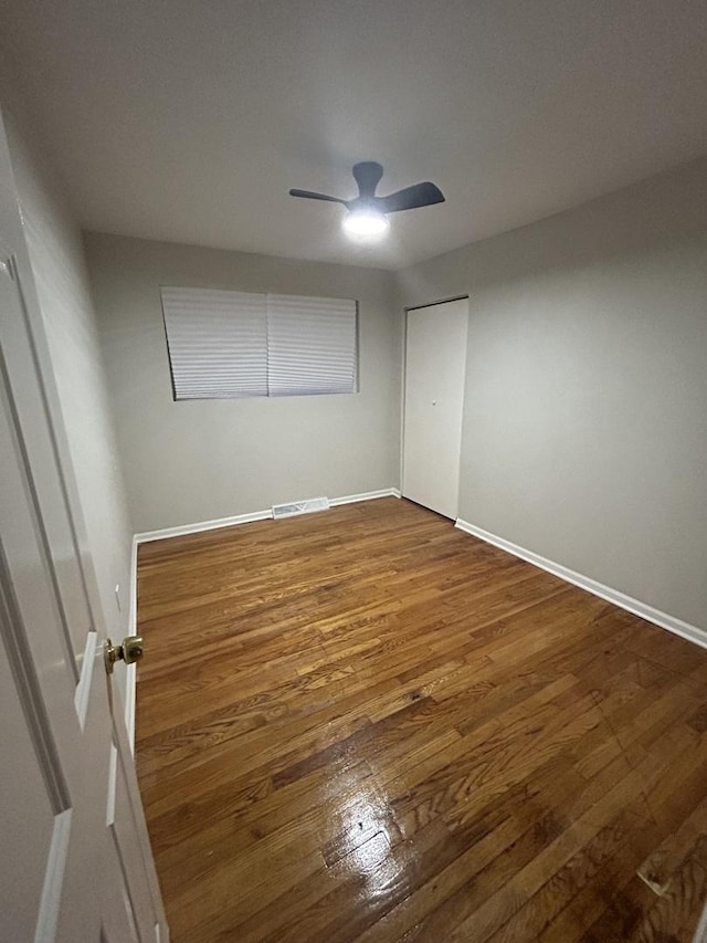 unfurnished bedroom featuring ceiling fan and dark hardwood / wood-style floors