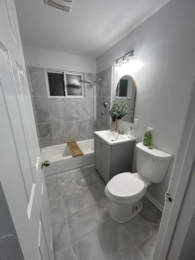 full bathroom with toilet, vanity, and tiled shower / bath