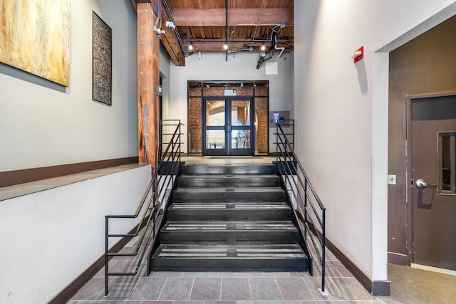 staircase featuring beam ceiling, french doors, and wooden ceiling