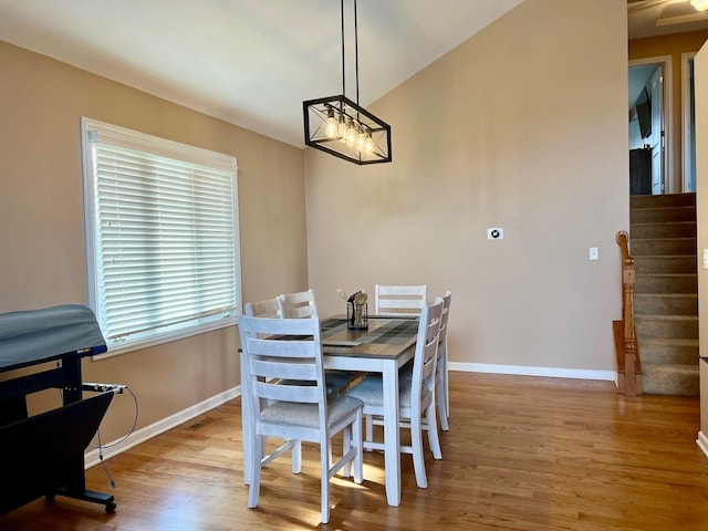 dining room with light hardwood / wood-style floors and vaulted ceiling