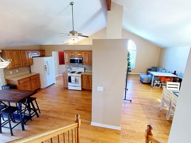 kitchen with ceiling fan, lofted ceiling, white appliances, decorative backsplash, and light wood-type flooring