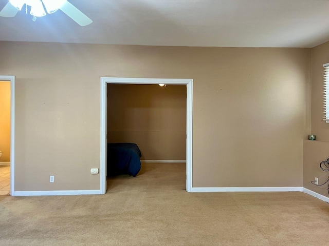 spare room with ceiling fan and light colored carpet