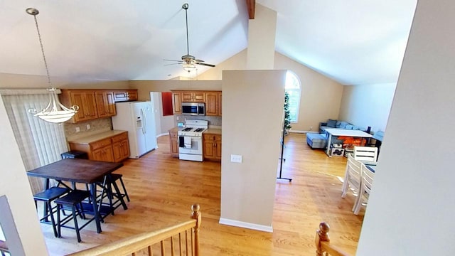 kitchen featuring ceiling fan, light hardwood / wood-style floors, vaulted ceiling, white appliances, and decorative backsplash