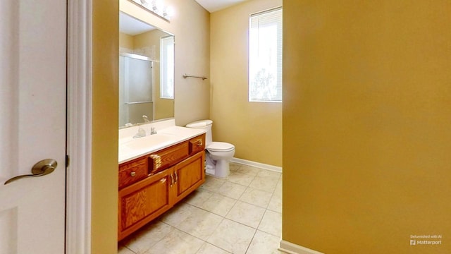 bathroom with toilet, vanity, tile patterned floors, and walk in shower