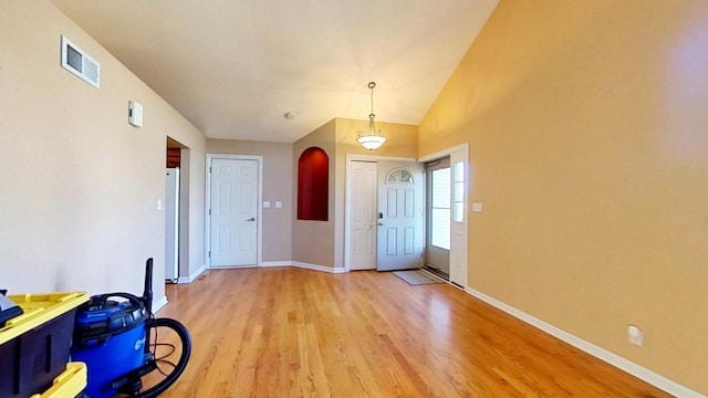 foyer with high vaulted ceiling and light hardwood / wood-style flooring