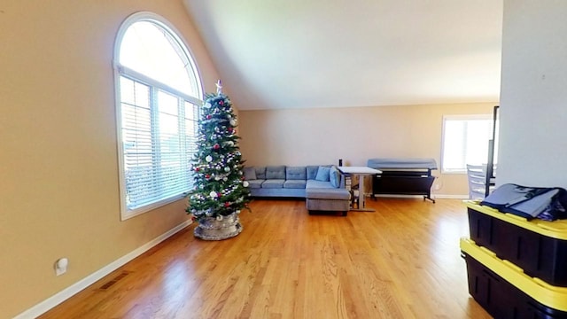 living room featuring vaulted ceiling and light wood-type flooring