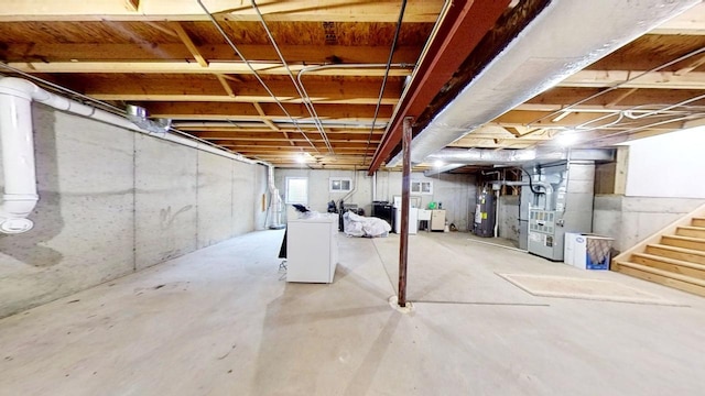 basement with heating unit, water heater, and washer / dryer