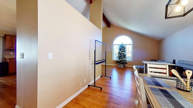 interior space with lofted ceiling with beams and light hardwood / wood-style flooring