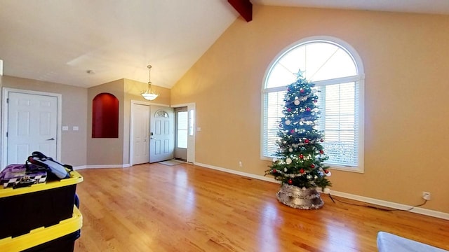 foyer entrance featuring hardwood / wood-style floors, beam ceiling, and high vaulted ceiling