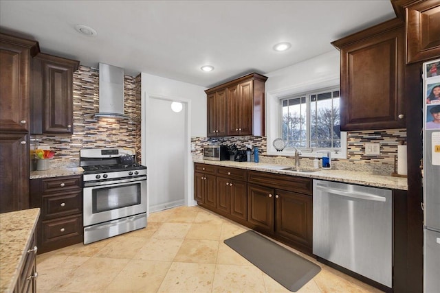 kitchen featuring decorative backsplash, sink, wall chimney range hood, and appliances with stainless steel finishes