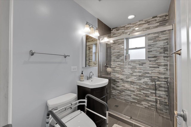 bathroom featuring vanity, toilet, and a shower with shower door