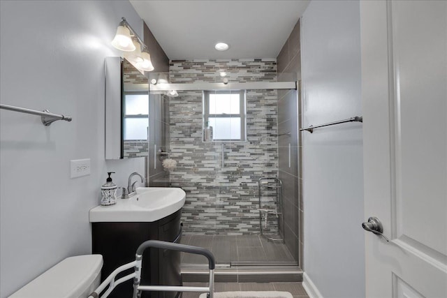 bathroom featuring tile patterned floors, toilet, an enclosed shower, and vanity