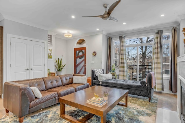 living room with crown molding, light hardwood / wood-style floors, and ceiling fan