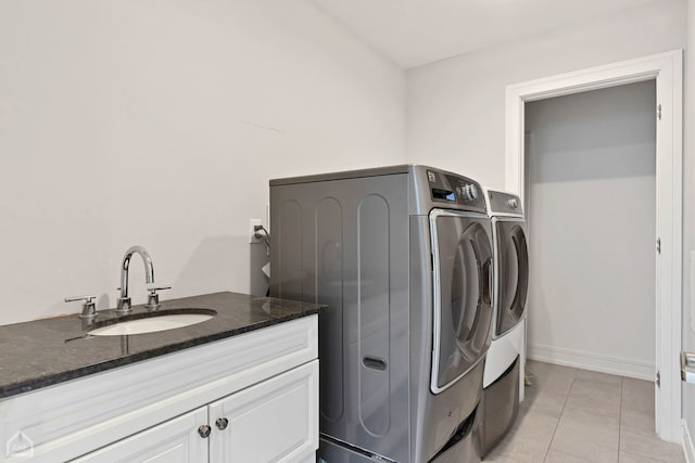 laundry room with cabinets, washing machine and dryer, sink, and light tile patterned flooring