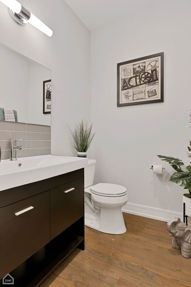 bathroom with vanity, backsplash, hardwood / wood-style flooring, and toilet