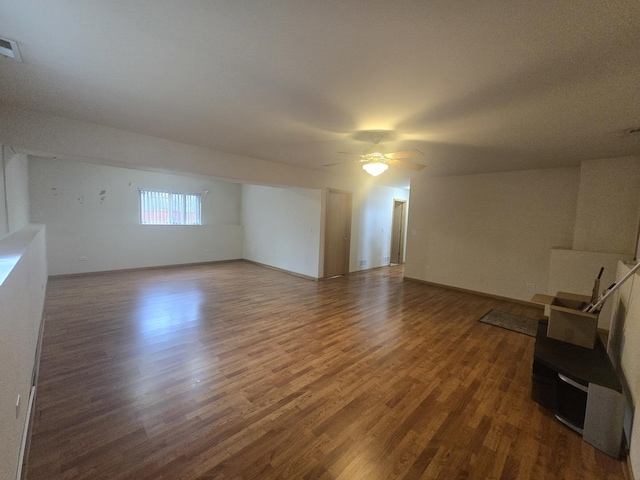 unfurnished living room with ceiling fan and dark hardwood / wood-style flooring