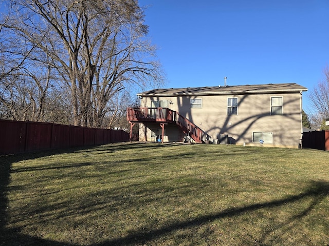 back of property featuring a deck and a lawn