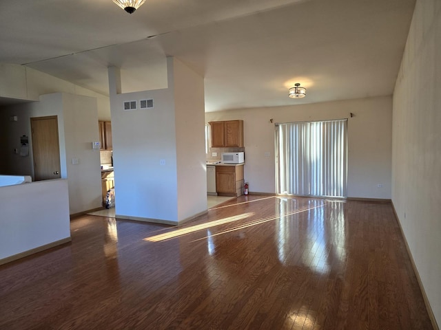 unfurnished living room featuring hardwood / wood-style flooring and vaulted ceiling