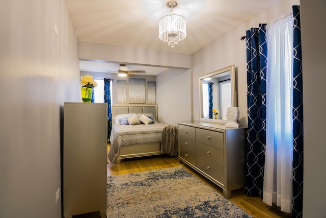 bedroom with a notable chandelier and light wood-type flooring