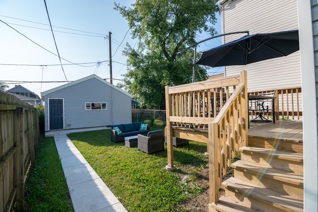 view of yard with outdoor lounge area, an outbuilding, and a deck