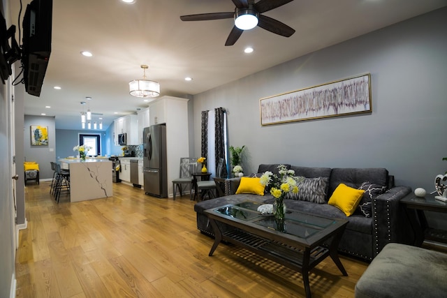 living room featuring ceiling fan and light wood-type flooring