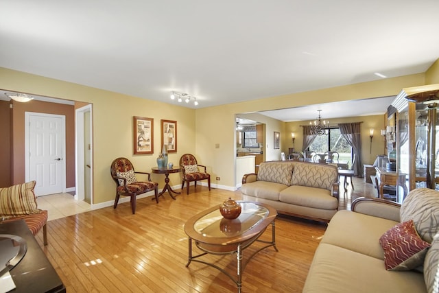 living room featuring an inviting chandelier and light hardwood / wood-style flooring