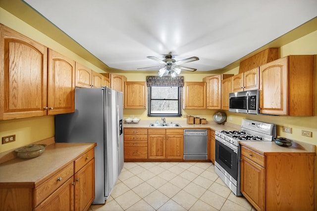 kitchen with light tile patterned floors, a sink, a ceiling fan, light countertops, and appliances with stainless steel finishes