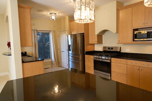 kitchen featuring light brown cabinets, sink, hanging light fixtures, stainless steel appliances, and a chandelier