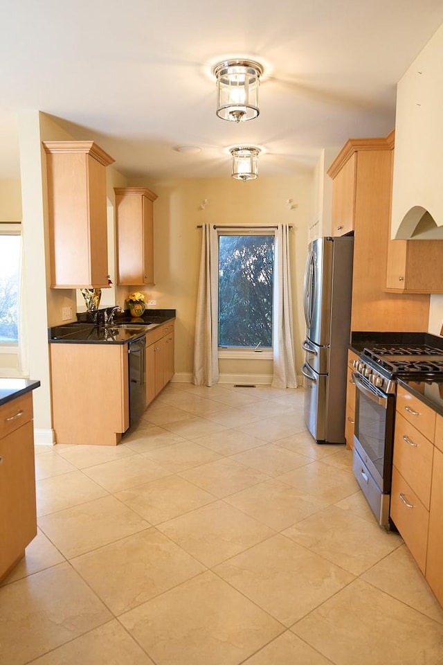 kitchen with light tile patterned flooring, light brown cabinets, stainless steel appliances, and sink