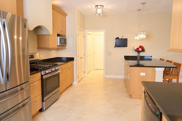 kitchen with a breakfast bar, stainless steel appliances, light brown cabinets, pendant lighting, and a kitchen island