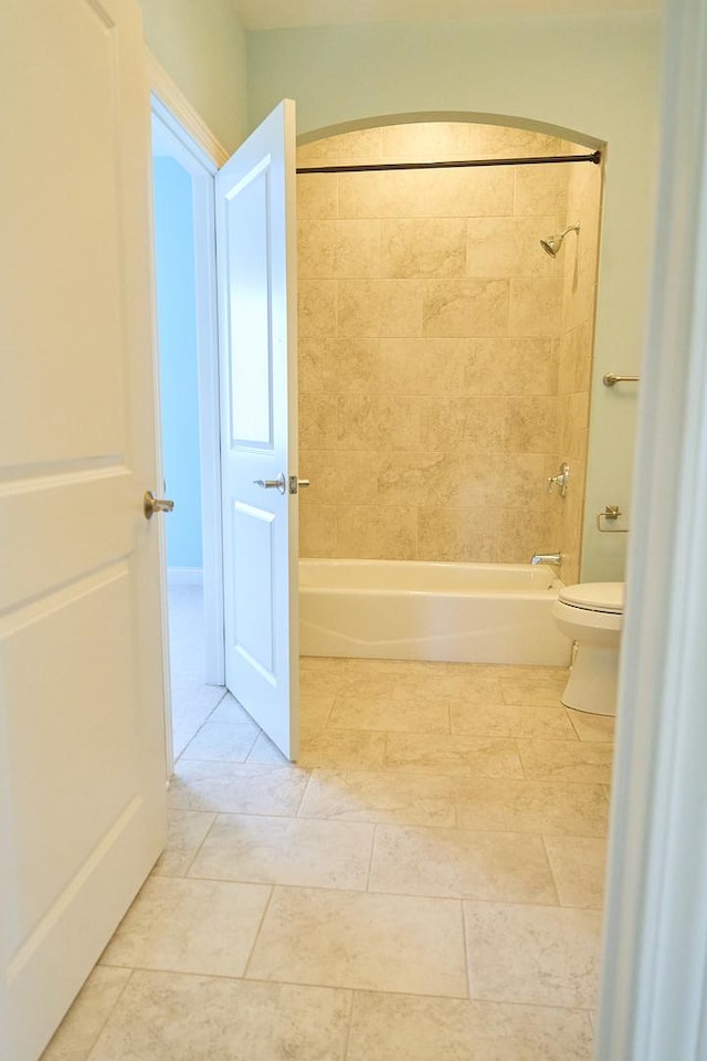 bathroom featuring toilet and tiled shower / bath