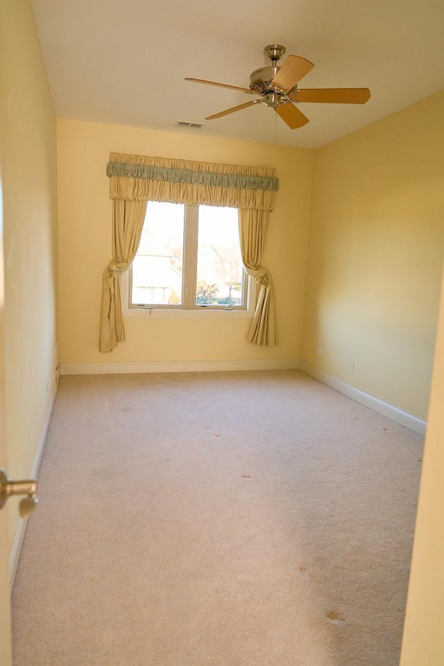 empty room featuring ceiling fan and carpet